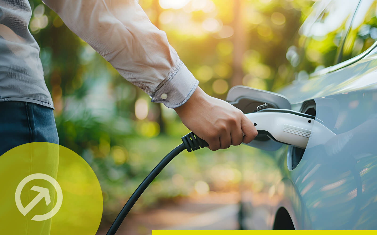 Person lädt ein E-Auto mit Ladekabel